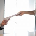 Image showing hands exchanging documents.